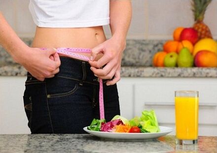 Dieta batean pisua galtzen ari den neska batek gerriaren tamaina neurtzen du